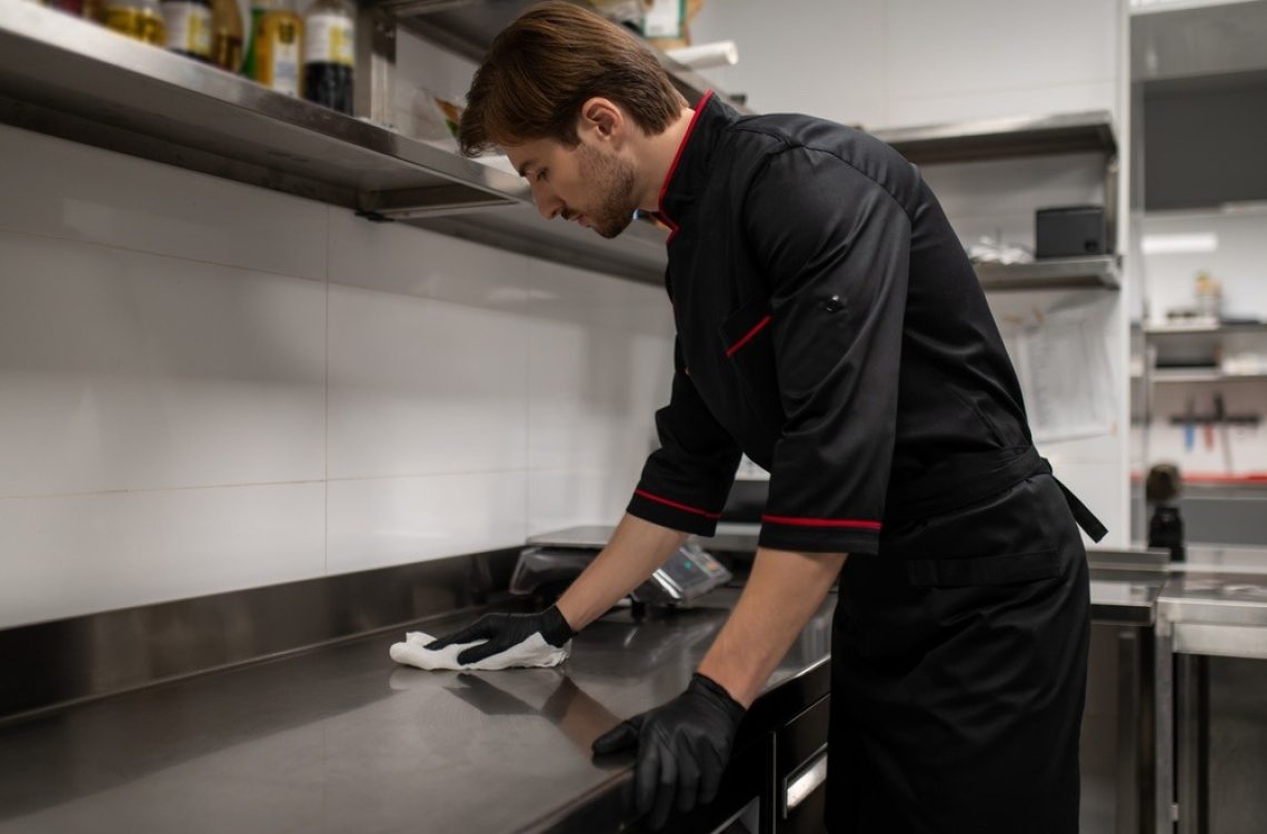 Chef,Cleaning,Kitchen,Counter,After,Cooking,In,Restaurant